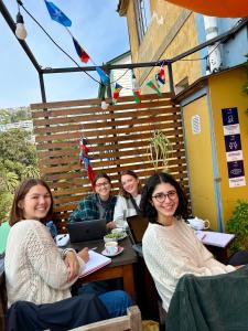 瓦尔帕莱索Meraki Hostel - Cerro Alegre - Valparaíso的坐在餐馆桌子上的一群妇女