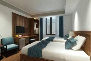 宁平Tam Coc Condelux Boutique Hotel & Travel的一间卧室配有两张床、一张桌子和一台电视。