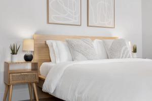 达尼亚滩Mango House en Dania Beach的卧室配有白色的床和木制床头板