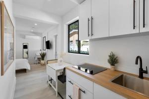 达尼亚滩Mango House en Dania Beach的厨房设有白色的墙壁、水槽和柜台。