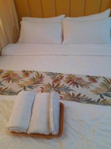 马尼拉Shell Residences by Amonbrey Suite nr airport的一张带两条毛巾和两个枕头的床