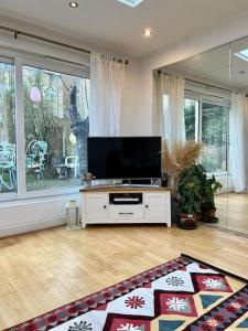伦敦Sunny London Garden Apartment的客厅配有餐桌上的平面电视