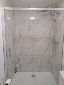 奥尔德姆1 Bedroom Flat Available的浴室设有白色大理石瓷砖和淋浴。