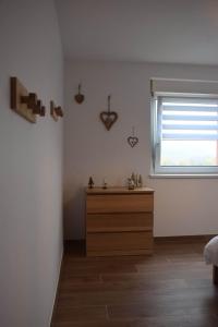 BernardswillerLa Perle d'Alsace的一间卧室设有木制梳妆台和窗户。