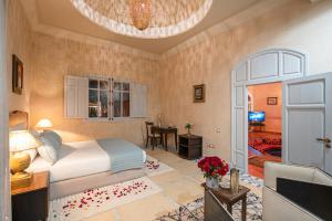 马拉喀什Palais Alcazar的一间卧室配有一张床,客厅配有桌子