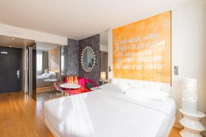 日内瓦尼维马诺特尔酒店的卧室配有白色的床和墙上的大画作