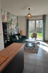 拉·里维耶尔·圣·秀La Maison Olivia的客厅配有绿色沙发和桌子