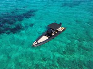 帕罗斯岛CycladesCharters: Discover Hidden Gems in Paros!的漂浮在蓝色水中的小船