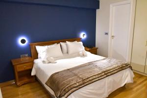 纳夫普利翁Porto Nafplio的一间卧室设有一张蓝色墙壁的大床