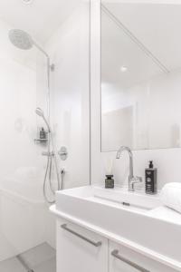 格拉茨limehome Graz - Argos by Zaha Hadid的白色的浴室设有水槽和淋浴。