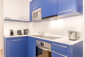 格拉茨limehome Graz - Argos by Zaha Hadid的蓝色的厨房配有水槽和微波炉