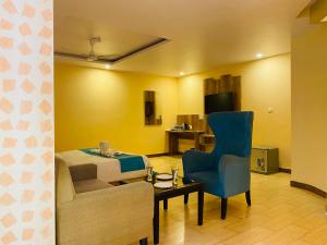 西姆拉Aachman Nature Valley Resort Shimla的酒店客房,配有一张床和一张蓝色椅子