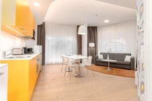 格拉茨limehome Graz - Argos by Zaha Hadid的厨房以及带桌子和沙发的客厅。