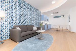 格拉茨limehome Graz - Argos by Zaha Hadid的带沙发和蓝白色墙壁的客厅