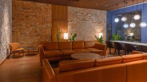 格但斯克Radisson Hotel & Suites, Gdansk, Wyspa Spichrzów的大堂配有沙发和桌椅