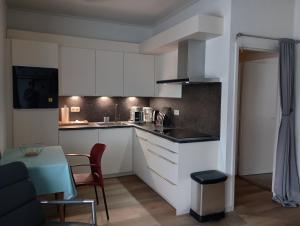 马斯特里赫特Aldenhof Appartementen的厨房配有白色橱柜和桌椅