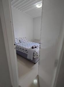 库亚巴Quarto em apartamento em Cuiabá的一间白色客房内的床铺卧室
