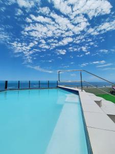 斯瓦科普蒙德Camere da Letto- Hotel-On-The Beach Self Catering的一座蓝天建筑的顶部游泳池