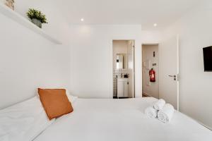 里斯本Lapa Stylish Apartments的白色卧室配有白色床和2条毛巾