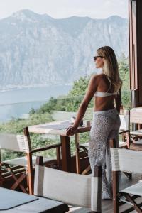 马尔切西内Hotel Querceto Wellness & Spa - Garda Lake Collection的站在桌子上望着山的女人