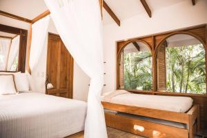 圣塔特蕾莎海滩Villas Almendros的带窗户的客房内的两张床
