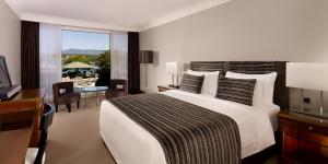 日内瓦Hotel President Wilson, a Luxury Collection Hotel, Geneva的卧室配有一张白色大床、书桌和书桌