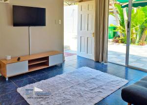 德班Glen Ashley Beach Villas的客厅配有平面电视和沙发。