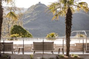 卡尔达罗Lake Spa Hotel SEELEITEN的一组椅子和一张桌子,上面有棕榈树