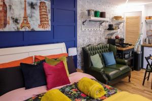 伯恩茅斯Le Chic Retreat - Luxury Hot Tub Getaway的客房配有带色彩缤纷的枕头和椅子的床。