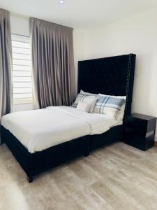 AshalebotweQuebella Luxury Home的卧室内一张带黑色床头板的床