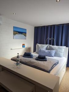 MustinFerienhaus am See mit Ruderboot的一间卧室配有一张带蓝色窗帘的大床