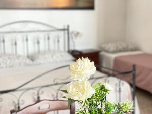 普蒂尼亚诺Arco Michele的一间带两张床的卧室和白色花瓶