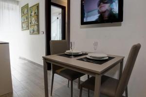 都灵Arsenale Turin Rooms的餐桌、椅子和墙上的电视