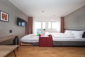 辛根Brera Serviced Apartments Singen的酒店客房设有两张床和一张桌子。