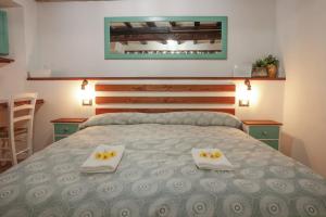 特雷维尼亚诺罗马诺Vicolo39 La casa a due passi dal Lago的一间卧室配有一张床,上面有两条毛巾