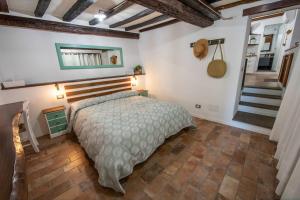 特雷维尼亚诺罗马诺Vicolo39 La casa a due passi dal Lago的一间带一张床的卧室,位于带楼梯的房间