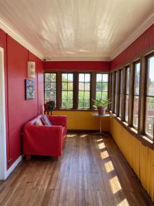 皮奇勒姆Hostal Kuyen的客厅设有红色的沙发和窗户。