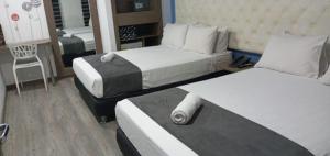 波哥大Plaza Miranda的酒店客房,配有两张床和椅子