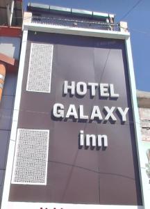哈里瓦Galaxy Inn Hotel的大楼一侧的酒店星系旅馆标志