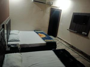 哈里瓦Galaxy Inn Hotel的酒店客房设有两张床和电视。