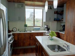 拉塔昆加BellaVista Casa de Montaña的厨房配有木制橱柜、水槽和窗户。