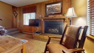 西黄石Trapper Condo Unit 7的客厅设有壁炉和电视。