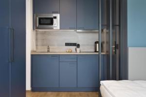 辛根Brera Serviced Apartments Singen的蓝色的厨房配有水槽和微波炉