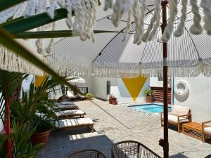 圣胡安La Mona Loiza Apartments Complex的一个带椅子的庭院和一个帐篷下的游泳池