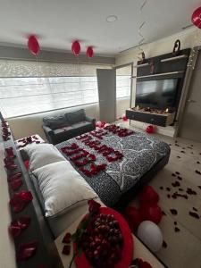 瓜亚基尔Depa de lujo con piscina y jacuzzi的卧室配有一张红色玫瑰花大床,位于地板上