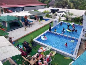 Casa LiLa Tiny Stay & Pool Kota Bharu,free wifi,free parking的游泳池的顶部景色,人们在游泳池里玩耍