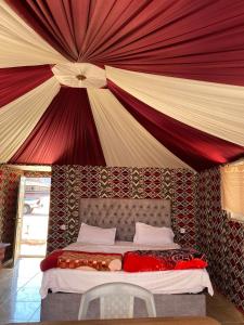 瓦迪拉姆Desert guide camp的一张位于带大型天花板的房间内的床铺