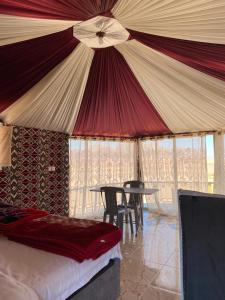 瓦迪拉姆Desert guide camp的一间卧室配有带桌椅的帐篷