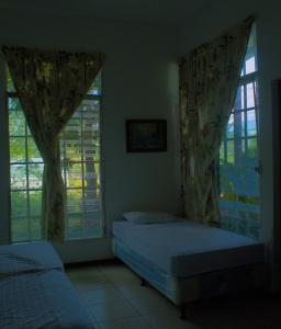 San MarcosHotel Boutique Sol de Oro的一间卧室设有两张床和两个窗户。