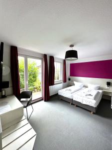 罗斯托克布林克曼多夫酒店的一间卧室设有两张床和紫色墙壁